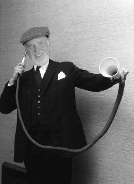 11th January 1963: A man demonstrating a long distance ear trumpet, at an exhibition of custom-made 19th century hearing aids in London. It is one of the many 19th Century hearing aids owned by Amplivox-Ultratone, and was originally made by F.C. & C.V. Rein & Sons. (Photo by John Franklin/BIPs/Getty Images)